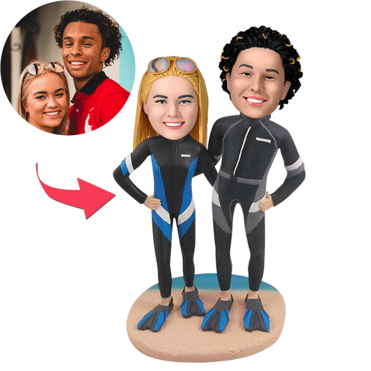 Custom diving couple bobblehead with engraved text on a beach, featuring MadeMine brand, showcasing detailed facial features and beach attire.