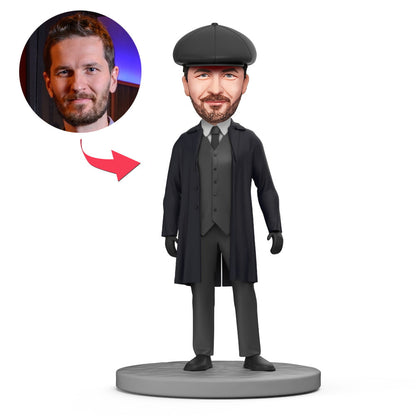 Zwart Shelby bobblehead van MadeMine met gegraveerde tekst, gedetailleerde kop en kleding, op een neutrale achtergrond.