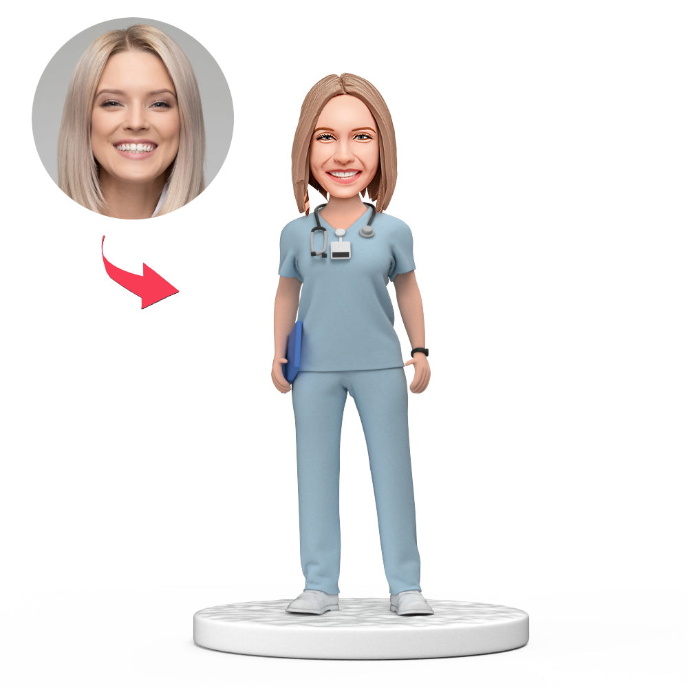 Persoonlijke vrouwelijke dokter bobblehead in lichtblauwe scrubs met gegraveerde tekst, gemaakt door MadeMine, voor Nationale Doktersdag.