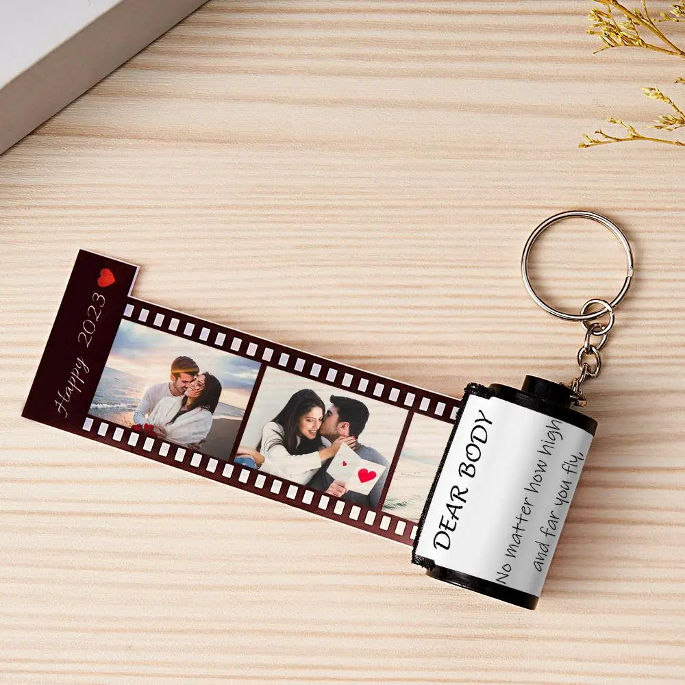MadeMine personalized photo film roll keychain with engraved image, displayed next to its elegant gift box.