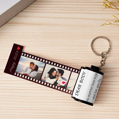 MadeMine personalized photo film roll keychain with engraved image, displayed next to its elegant gift box.